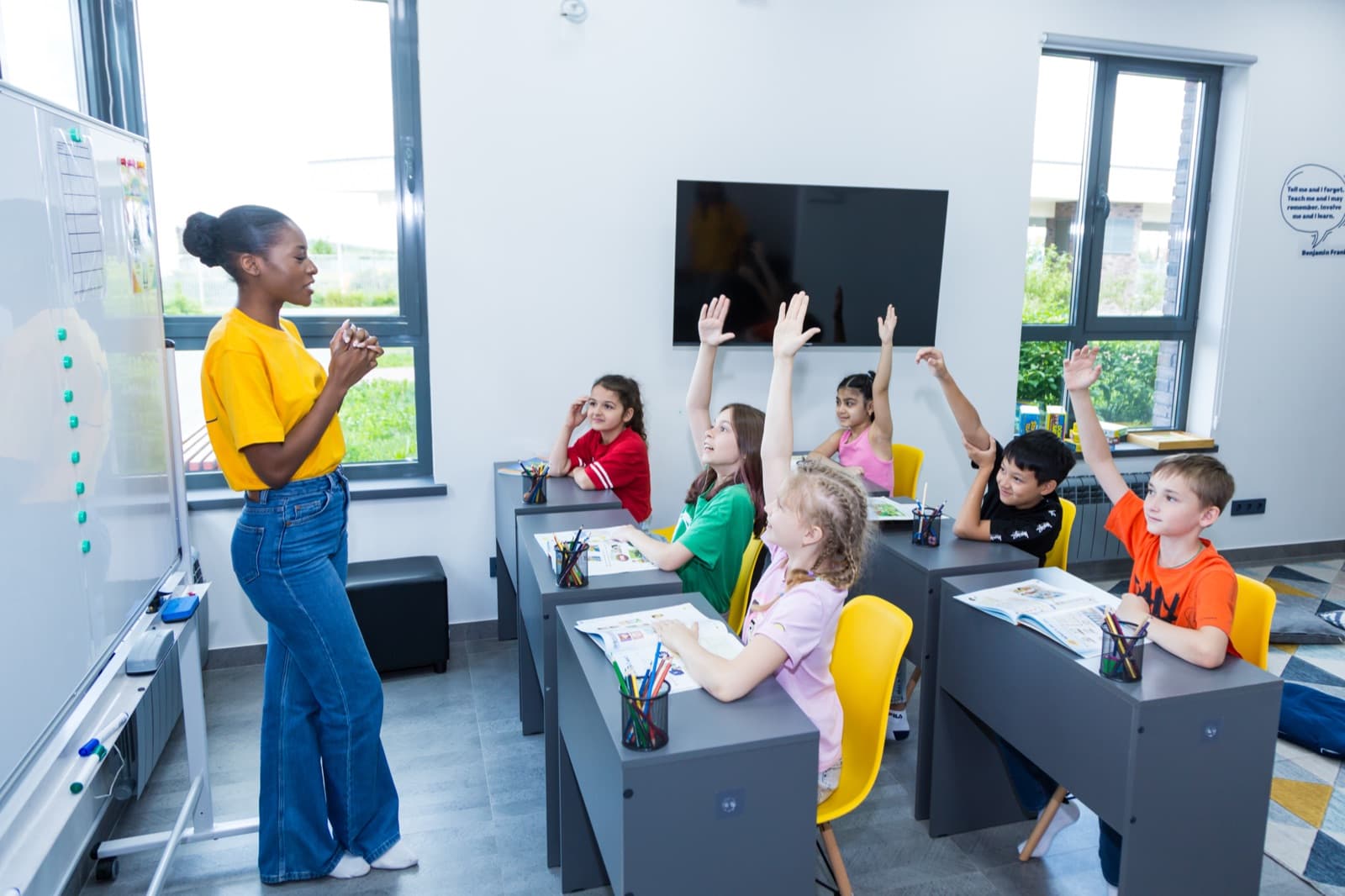 Kids raising hands in class